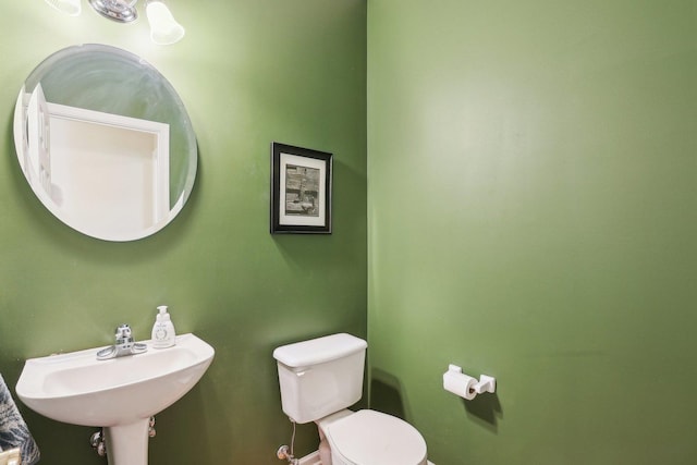 34457 N Bluestem Rd, Round Lake, IL 60073 - half bathroom featuring toilet, baseboards, and a sink