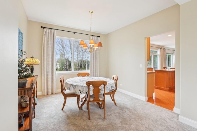 34457 N Bluestem Rd, Round Lake, IL 60073 - dining area with light colored carpet, baseboards, and a notable chandelier