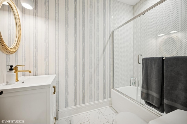 bathroom featuring marble finish floor, vanity, shower / bath combination with glass door, and wallpapered walls