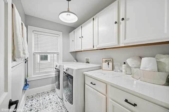 clothes washing area featuring cabinet space, washing machine and dryer, baseboards, and tile patterned flooring