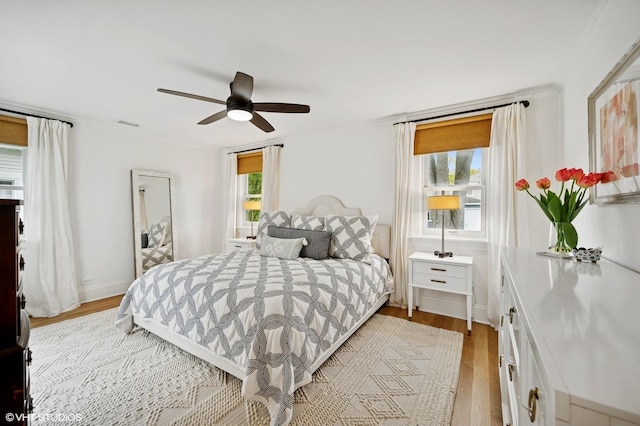 bedroom featuring visible vents, light wood-style flooring, and a ceiling fan