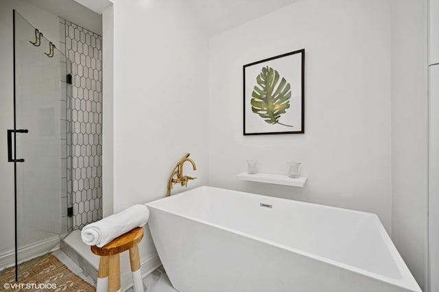 full bath featuring a stall shower and a freestanding tub