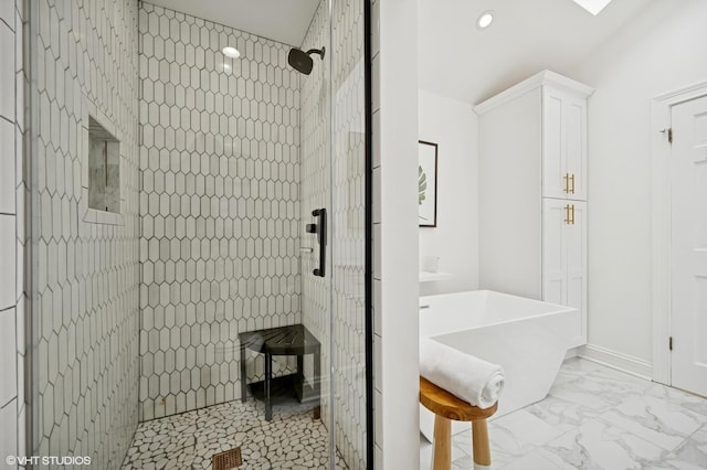 full bathroom featuring a freestanding bath, recessed lighting, marble finish floor, and a tile shower