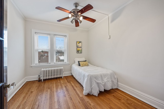 bedroom featuring radiator heating unit, crown molding, and baseboards