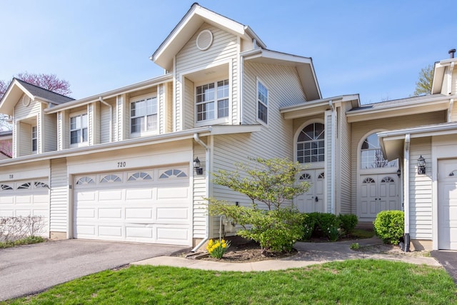 townhome / multi-family property with an attached garage and driveway