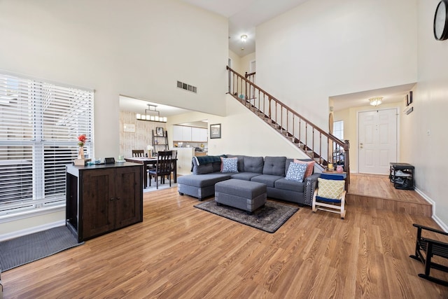 1296 Lake Shore Dr, Carol Stream, IL 60188 - living area with visible vents, a high ceiling, light wood-style floors, and stairway