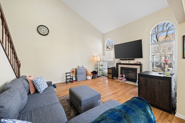 1296 Lake Shore Dr, Carol Stream, IL 60188 - living area featuring a tiled fireplace, wood finished floors, a healthy amount of sunlight, and high vaulted ceiling