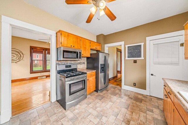 2523 Woods St, West Brooklyn, IL 61378 - kitchen with stainless steel appliances, baseboards, backsplash, ceiling fan, and light countertops