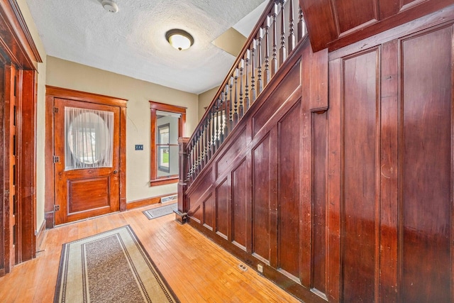 2523 Woods St, West Brooklyn, IL 61378 - entryway with light wood-style flooring, a textured ceiling, baseboards, and stairway