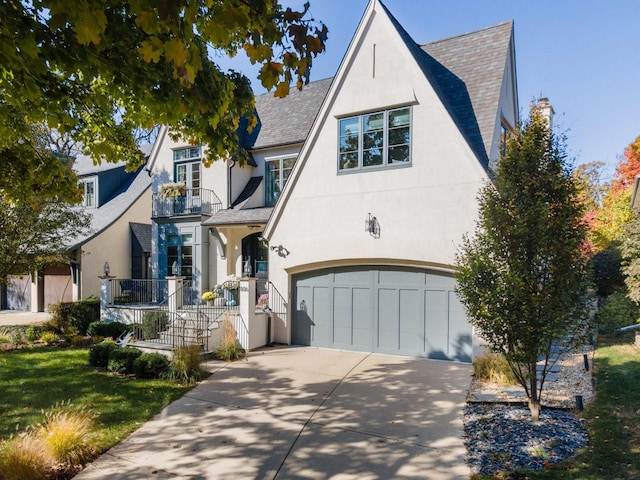 806 Randall Ave, Downers Grove, IL 60515 - tudor-style house featuring a garage, concrete driveway, a balcony, and stucco siding