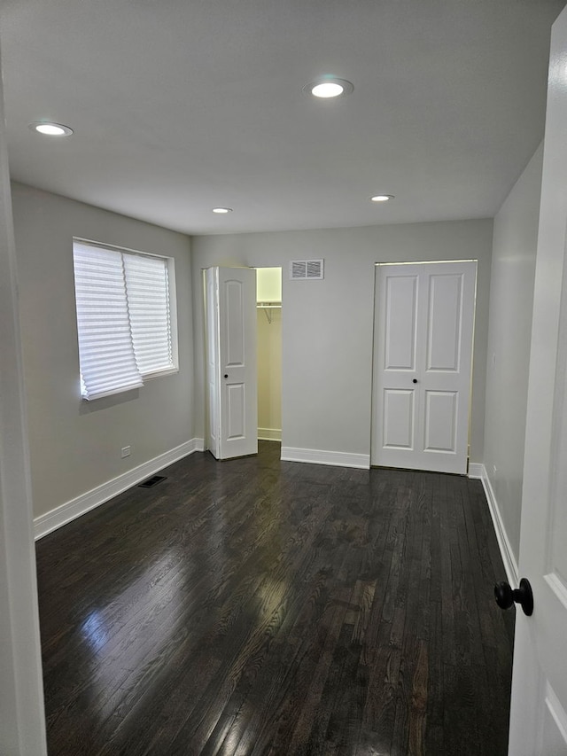 unfurnished bedroom featuring recessed lighting, visible vents, baseboards, and dark wood-style floors