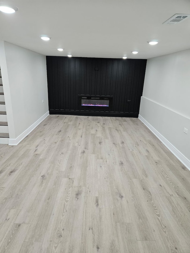 finished basement featuring light wood-type flooring, recessed lighting, baseboards, and visible vents