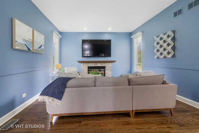 living room featuring baseboards, visible vents, and a glass covered fireplace