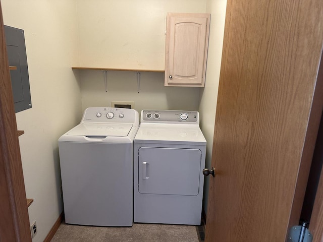 washroom featuring cabinet space, electric panel, and washing machine and clothes dryer