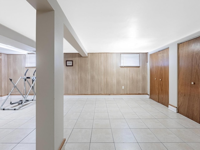 basement featuring wood walls and light tile patterned floors