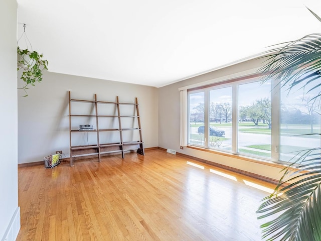 spare room featuring baseboards, visible vents, and light wood-type flooring