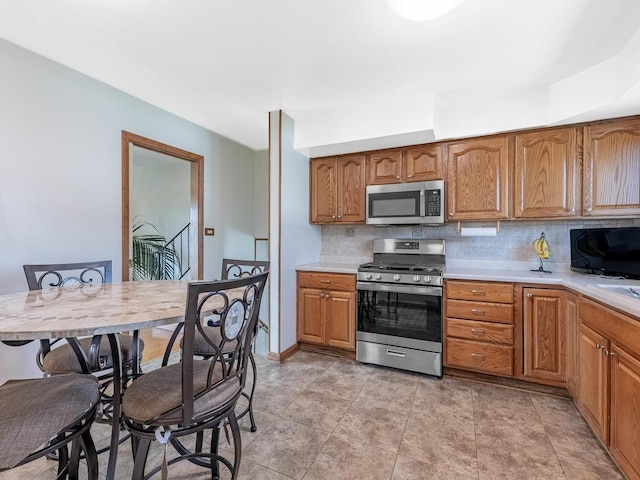 kitchen with light countertops, backsplash, and appliances with stainless steel finishes