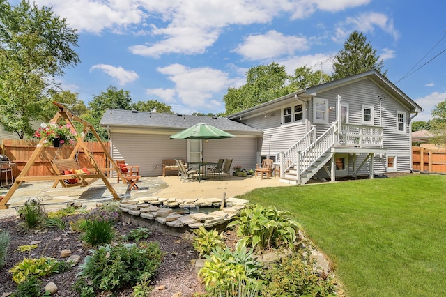 rear view of property with a yard, fence, stairs, and a patio area