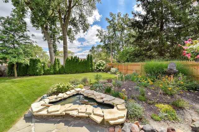 view of yard featuring a fenced backyard and a fire pit