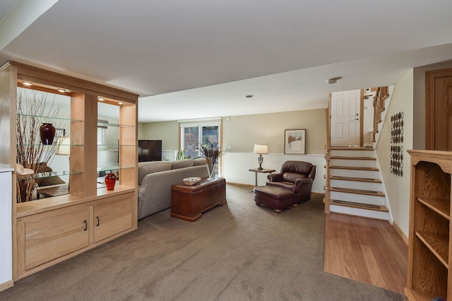 carpeted living area featuring stairway