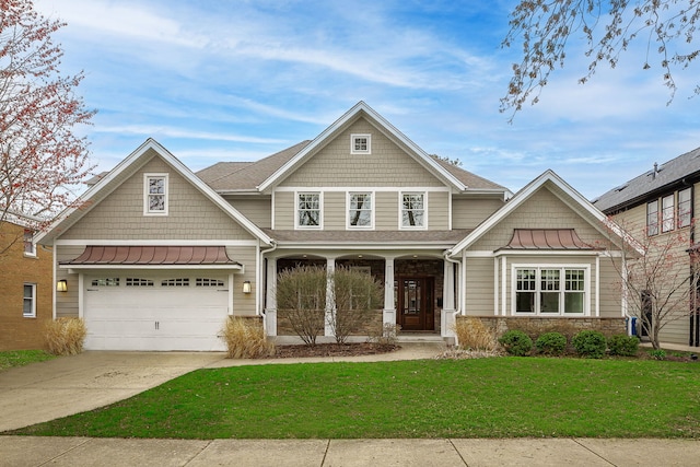 craftsman-style home featuring concrete driveway, stone siding, covered porch, a front yard, and a standing seam roof