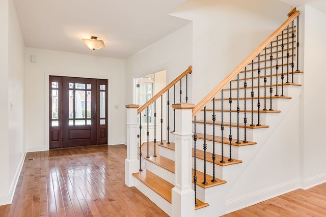 entrance foyer with baseboards, stairway, and hardwood / wood-style flooring