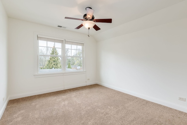 carpeted spare room with baseboards, a ceiling fan, and visible vents
