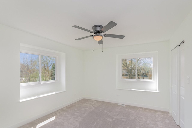 unfurnished room with baseboards, light colored carpet, and ceiling fan