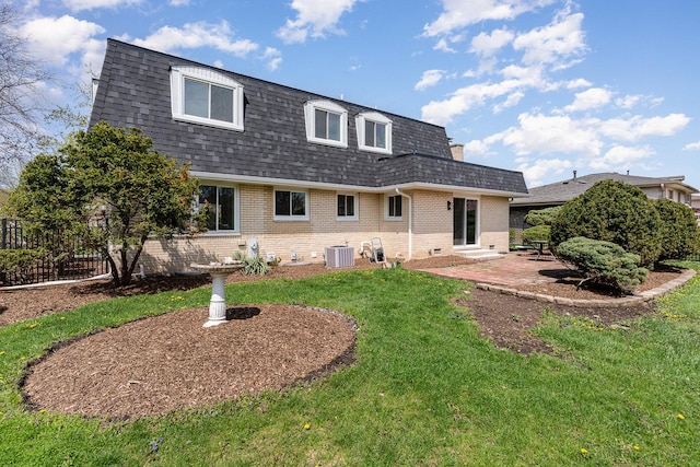 rear view of house featuring a patio area, central air condition unit, a lawn, a shingled roof, and mansard roof