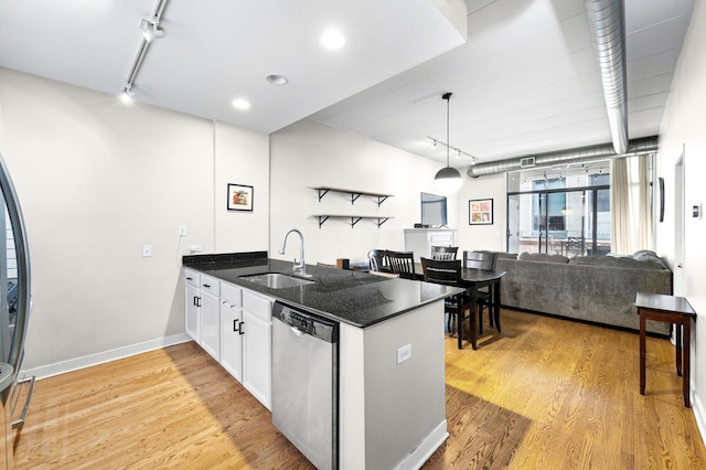 kitchen featuring a sink, stainless steel dishwasher, rail lighting, a peninsula, and light wood finished floors