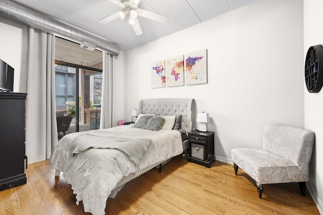 bedroom featuring access to exterior, wood finished floors, a ceiling fan, and baseboards