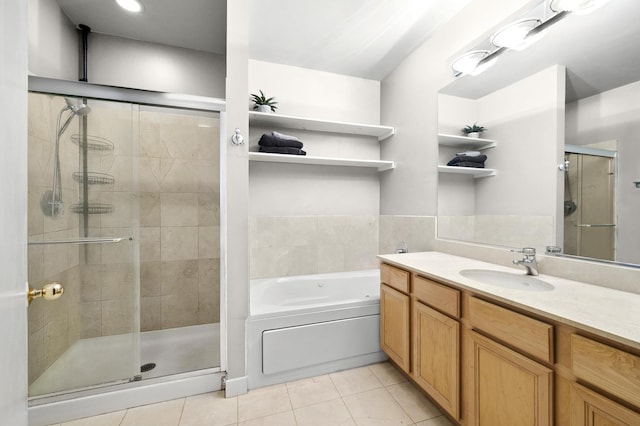 full bath featuring tile patterned floors, a shower stall, a garden tub, and vanity