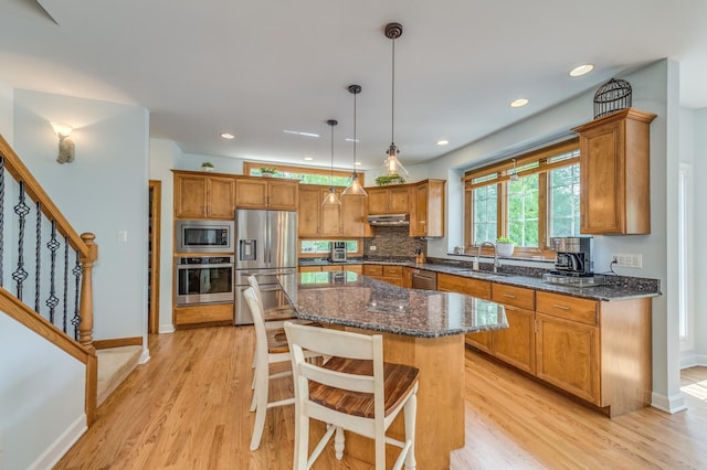 3908 Royal Portrush Dr, Naperville, IL 60564 - kitchen with appliances with stainless steel finishes, brown cabinetry, under cabinet range hood, light wood-type flooring, and recessed lighting