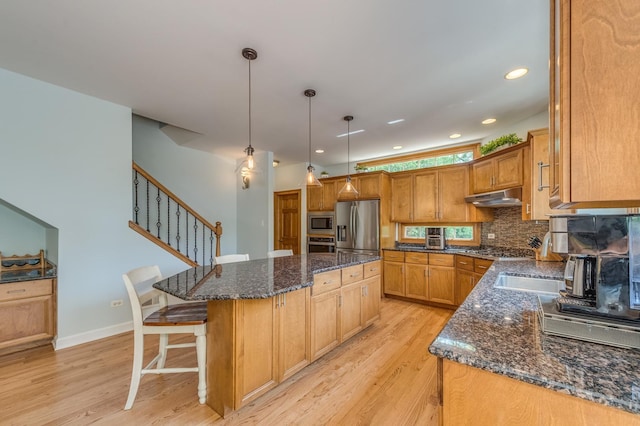 3908 Royal Portrush Dr, Naperville, IL 60564 - kitchen with stainless steel appliances, under cabinet range hood, a center island, light wood-type flooring, and decorative backsplash