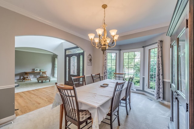 3908 Royal Portrush Dr, Naperville, IL 60564 - dining area with arched walkways, light carpet, a chandelier, crown molding, and baseboards