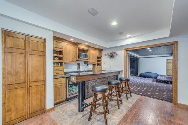 3908 Royal Portrush Dr, Naperville, IL 60564 - kitchen with stainless steel microwave, open shelves, beverage cooler, a breakfast bar area, and light wood-style floors