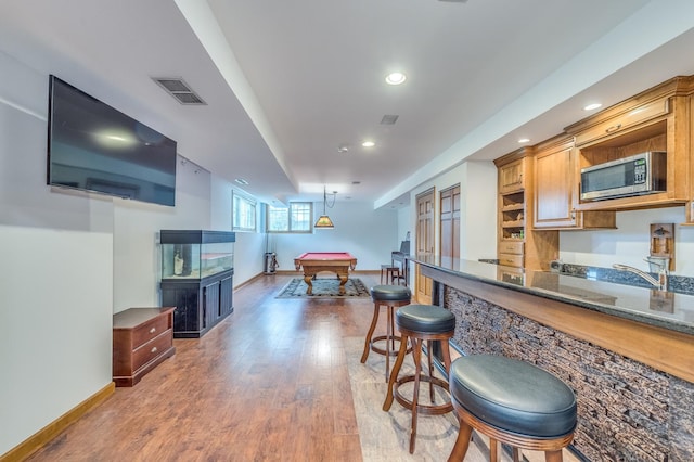 3908 Royal Portrush Dr, Naperville, IL 60564 - kitchen featuring stainless steel microwave, billiards, wood finished floors, a breakfast bar, and baseboards