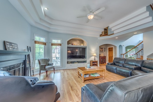 3908 Royal Portrush Dr, Naperville, IL 60564 - living area with a fireplace, a ceiling fan, wood finished floors, arched walkways, and stairs