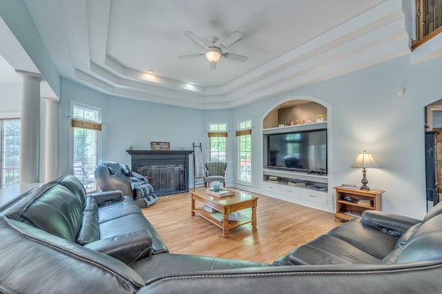 3908 Royal Portrush Dr, Naperville, IL 60564 - living area with ceiling fan, a fireplace, wood finished floors, a raised ceiling, and ornate columns