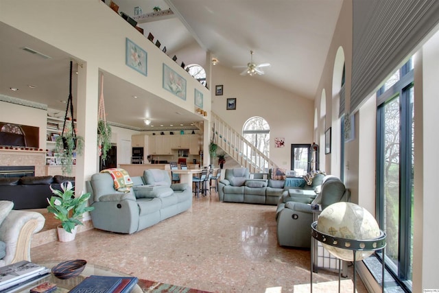 5620 Ridgeline Dr, Quincy, IL 62305 - living room with high vaulted ceiling, a fireplace, ceiling fan, stairs, and speckled floor