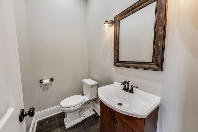 2642 N Drake Ave, Chicago, IL 60647 - bathroom featuring baseboards, toilet, vanity, and wood finished floors