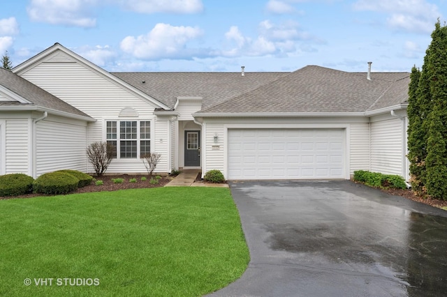 view of front of house featuring an attached garage, a shingled roof, a front lawn, and driveway