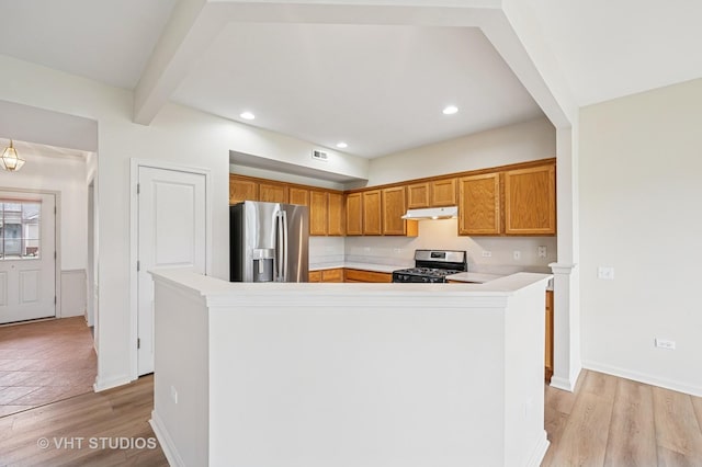 kitchen with visible vents, light countertops, under cabinet range hood, light wood-style flooring, and appliances with stainless steel finishes
