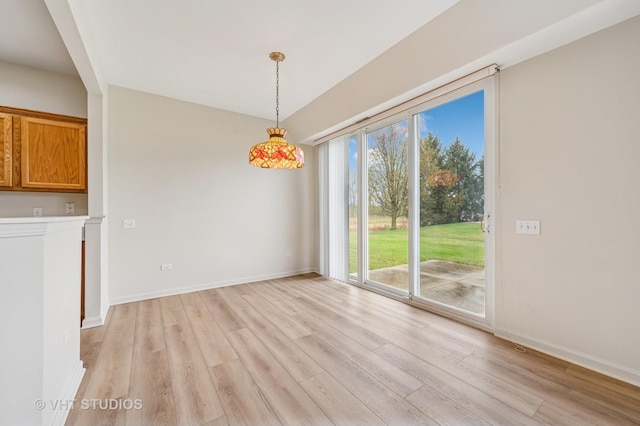 unfurnished dining area with baseboards and light wood finished floors