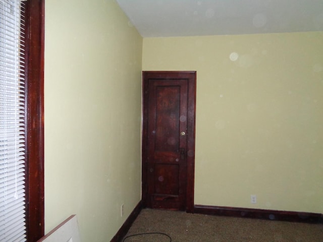 carpeted empty room featuring baseboards
