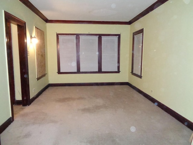 carpeted spare room with baseboards and ornamental molding