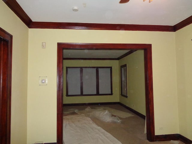 corridor with carpet flooring, baseboards, and ornamental molding
