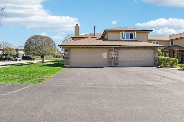 view of front of home featuring brick siding, a garage, a front yard, and aphalt driveway