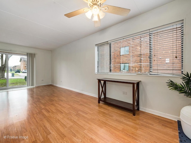 unfurnished room featuring baseboards, a ceiling fan, and light wood finished floors
