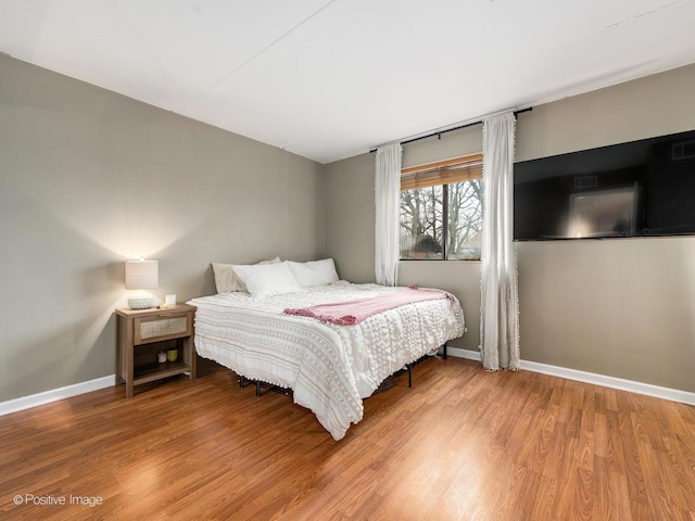 bedroom with baseboards and wood finished floors